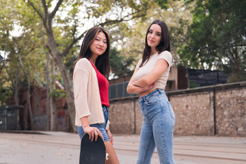 Naklejka premium two young women posing happy and smiling looking at camera, concept of female friendship and teenager lifestyle