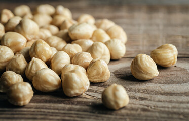 Heap of roasted hazelnuts close-up on a wooden background.