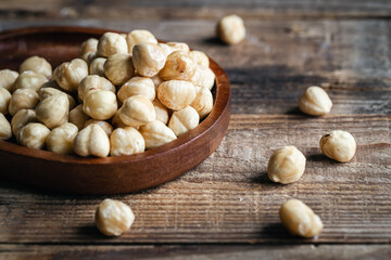 Heap of roasted hazelnuts close-up on a wooden background.