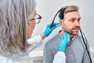 Handsome man during tympanometry or impedance audiometry and test of middle-ear function with...