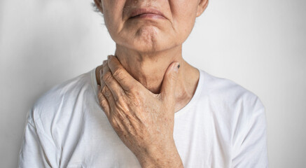 Tightness at the neck of Asian elder man. Concept of sore throat, pharyngitis, laryngitis,...