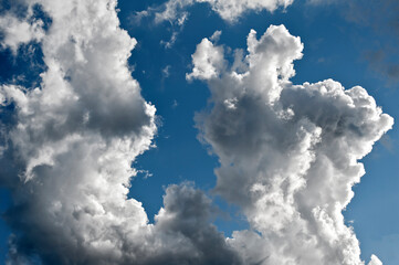 Aufsteigende, zerzauste Haufenwolken am blauem Himmel bei schönem Sommerwetter