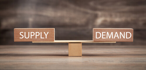 Supply and Demand word on wooden balance scales. Business concept
