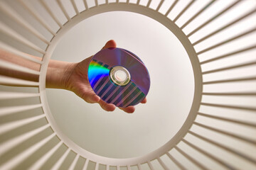 The DVD disc is thrown into the trash for disposal and recycling. View from below. The concept of...