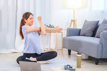 Young Asian healthy woman exercising with laptop at home