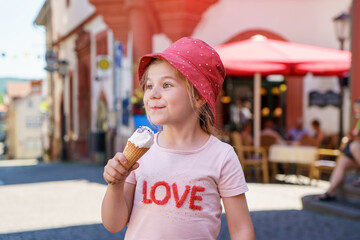 Beautiful little girl eats ice-cream in the summer. Happy funny preschool girl with sweet ice cream...