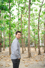 Man with beard and plaid shirt of aesthetic lumberjack in the middle of nature in portrait looking at camera.