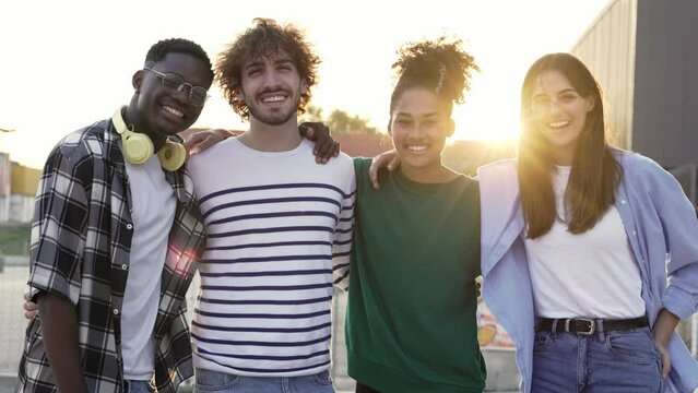 Group of young diverse multi-ethnic friends enjoying good moments and having fun together outdoors in the city at sunset - Youth Portrait