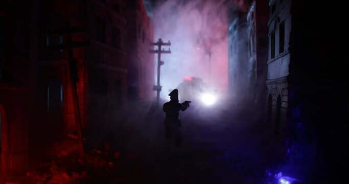 Police raid at night and you are under arrest concept. Silhouette of police car on backside. Image with the flashing red and blue police lights at foggy background.