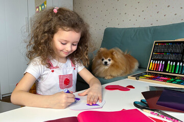 little beautiful girl handmade heart card craft for valentine's day. Cute child with friend dog DIY...