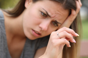 Sad teen looking at her engagement ring