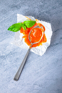 Homemade tomato sauce with spoon and mint leaves kept on tissue paper