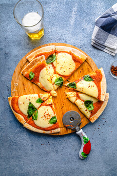 Freshly cooked slices of pizza with cutter on table