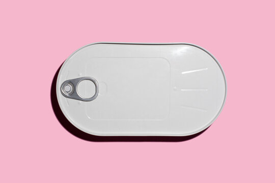 Metal can lying against pink background