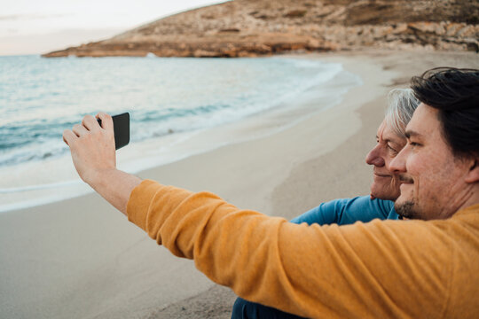 Happy father with son taking selfie through mobile phone