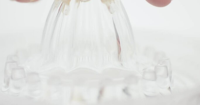 Female hand squeezes fresh lime juice on glass squeezer in close up
