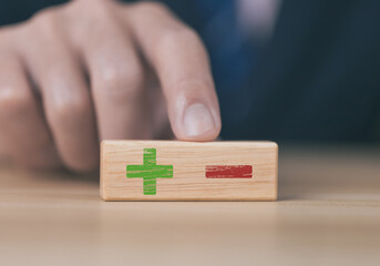 wooden block Show plus and minus symbols. The concept of opposites, decisions, and uncertainty.	