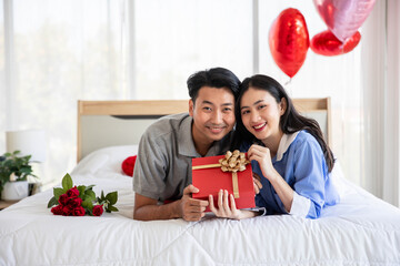 Beautiful young couple surprise with rose and gift in bedroom,Valentine's Day  concept.