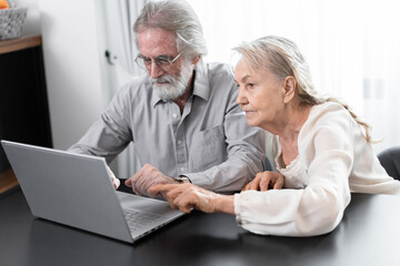 Fototapeta premium Older caucasian couple with tablet computer in living room at home