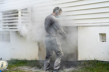Cutting concrete wall with angle grinder and diamond disk.