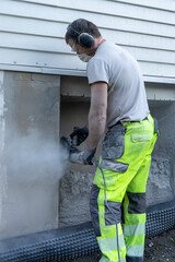 Fototapeta premium Adult man cutting beton hose wall.