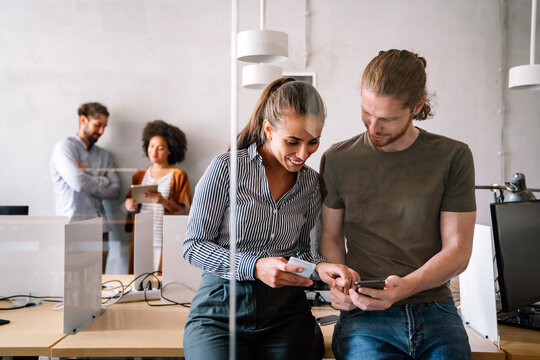 Smiling diverse colleagues gather in boardroom brainstorm discuss financial statistics together