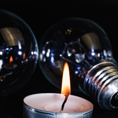 Electric lamp and candle on a dark background. Incandescent lamp and candle. No or power outage....