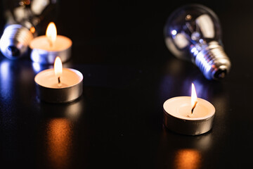 Electric lamp and candle on a dark background. Incandescent lamp and candle. No or power outage....