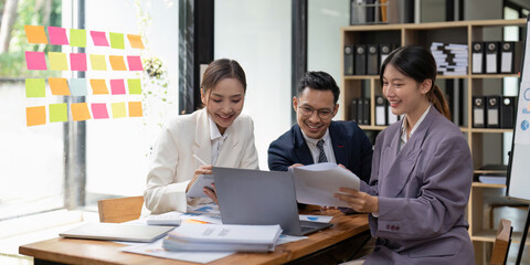 Group of young business people working and communicating while sitting at the office desk together with colleagues. Project and Business concept