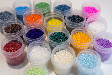 Items for beading - boxes with beads on the table. Development of creative abilities in children. view from above.