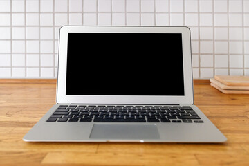 Laptop computer with blank mockup screen on kitchen counter