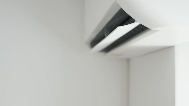 Air Conditioning Blowing Fresh Cool Air in the Office Changing the Room Temperature. Cooling Device Technology in Function. Split System. Shooting with an Air-Conditioner Working on a Hot Summer Day.