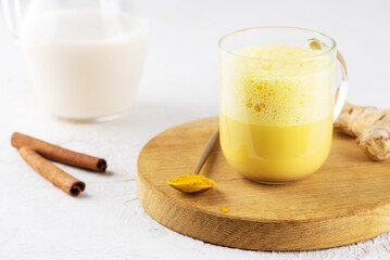 Golden milk from almond milk, ginger, turmeric and cinnamon in a cup, sugar and lactose free.