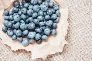 Bunch of blueberries collected in a piece of crumpled craft paper.