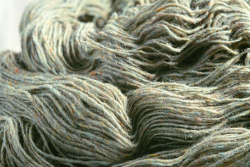 Threads of natural organic sheep wool. Unwound skein of olive green knitting yarn.