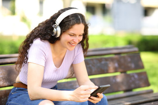 Woman with headphones watching content on smartphone
