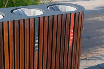 Closeup of wooden public waste bin for separation trash, sections of cans and paper