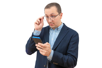 Surprised young businessman holding phone, looking at mobile phone, reading news on white background