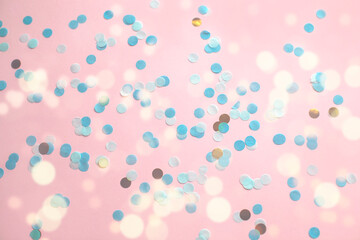 Blurred background. Blue confetti on pink paper. Sequins. Festive mood for your design. 