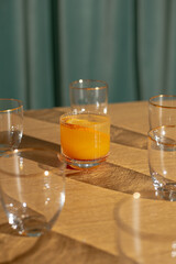 Cocktail with slice of orange and ice on the corner of wooden table 