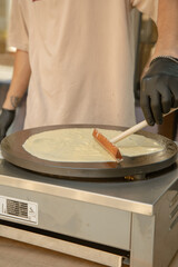 male cook bakes crepe on the stove