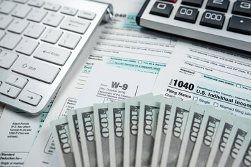Obraz premium business accounting concept - 1040 tax form with pen calculator us dollar bills