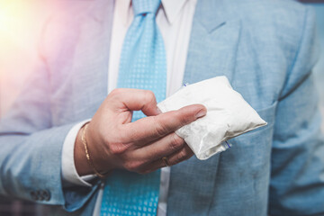 Young business man in suit hold package with  cocaine drugs