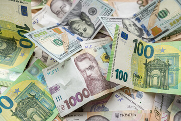 Obraz na płótnie Canvas 100 european money, 100 dollar and 1000 ukrainian hryvnia uah exchange concept, finance background.