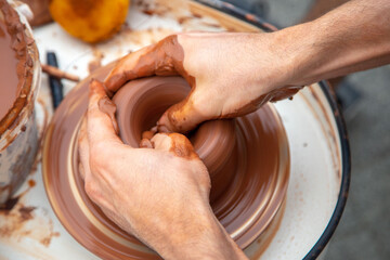 close-ups of the potter's hands making a jar from clay