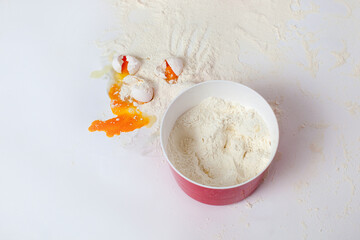 Flour and broken eggs. Mess in the kitchen. Close-up. White background. 