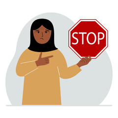 A woman holds a red stop sign in his hand.
