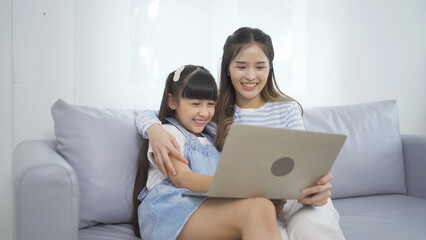 Portrait of happy smiling Asian Family. A student using computer laptop notebook device online at...