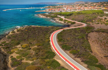 Beautiful European sea coast and empty curved road in summer time. View of the road along the coast from the drone. Travel by car concept