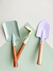 Flat lay composition with gardening tools on light green background